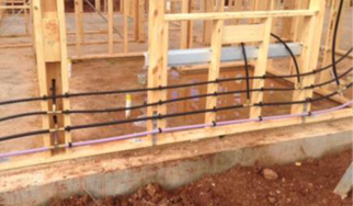 Photo of a plumbing installation showing in-wall non-drinking and drinking water pipework