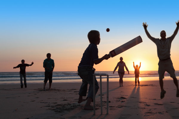 Photo: Family playing cricket on beach