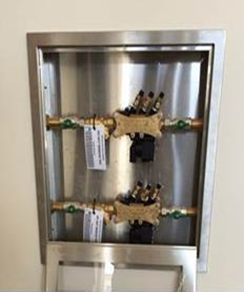 Photo of a reduced Pressure Zone Backflow Devices in in-wall stainless steel tundish box