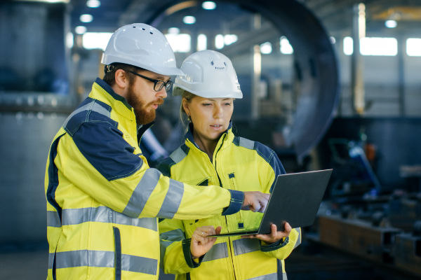 Photo: people working on laptop in industrial setting